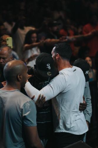 Saints QB Derek Carr comforts a man at "A Night of Worship"